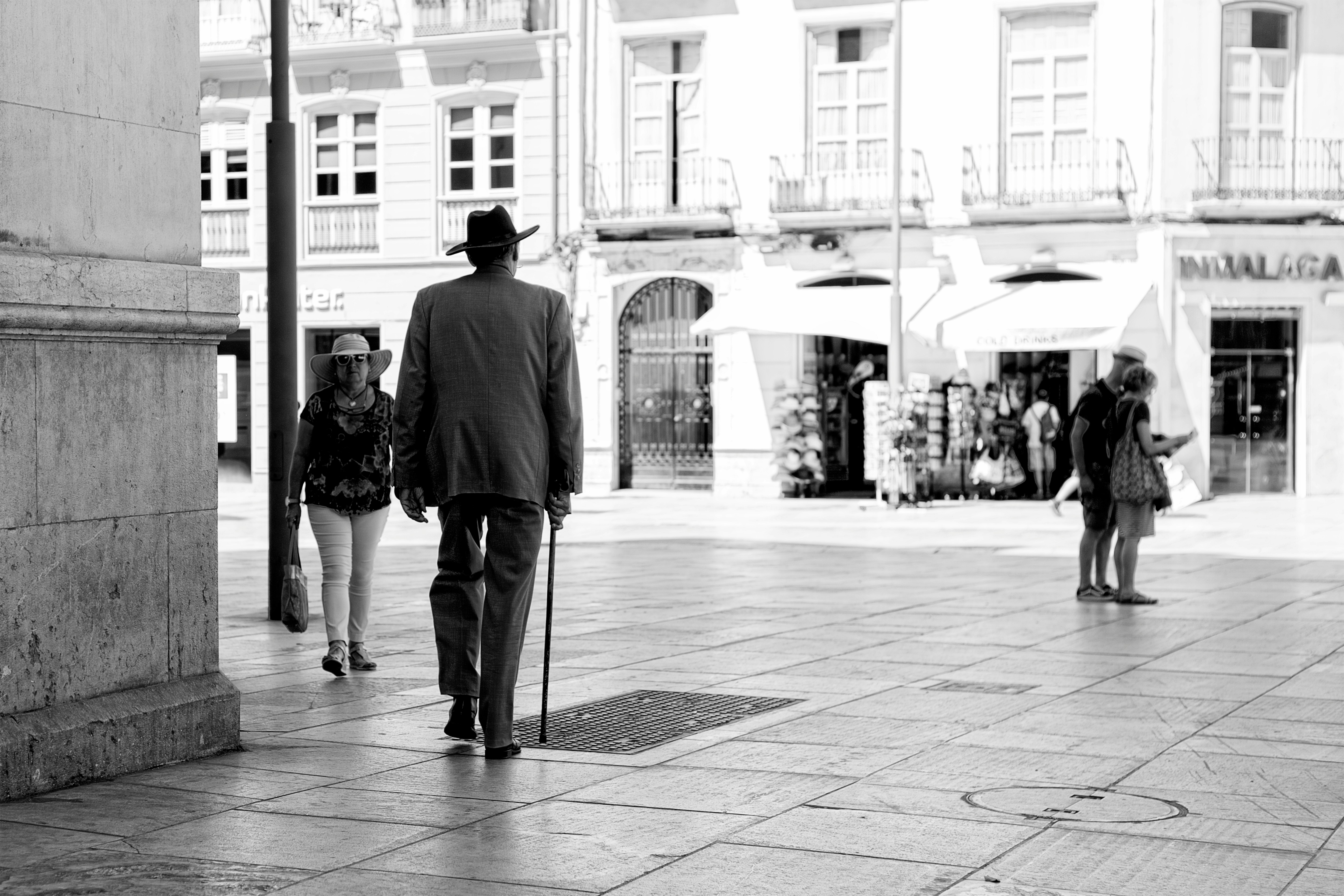 man in black jacket walking on sidewalk during daytime